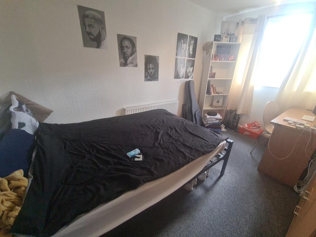 A cozy single bedroom with a comfortable bed, a...