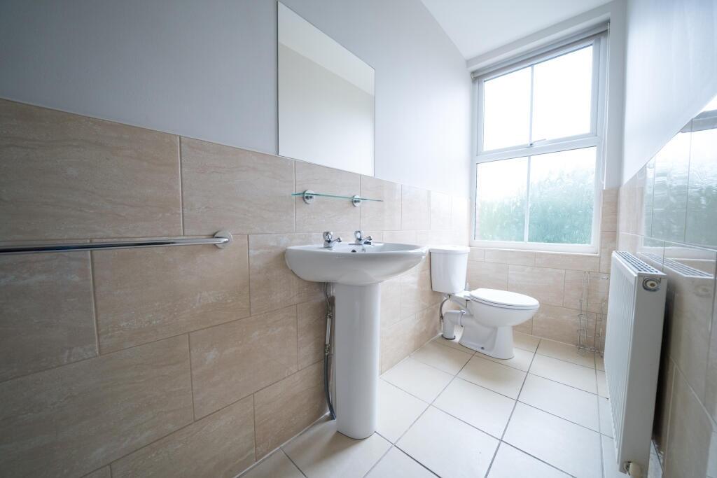 Bright and clean bathroom featuring a large win...