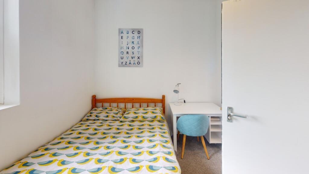 A bright and tidy single bedroom featuring a co...