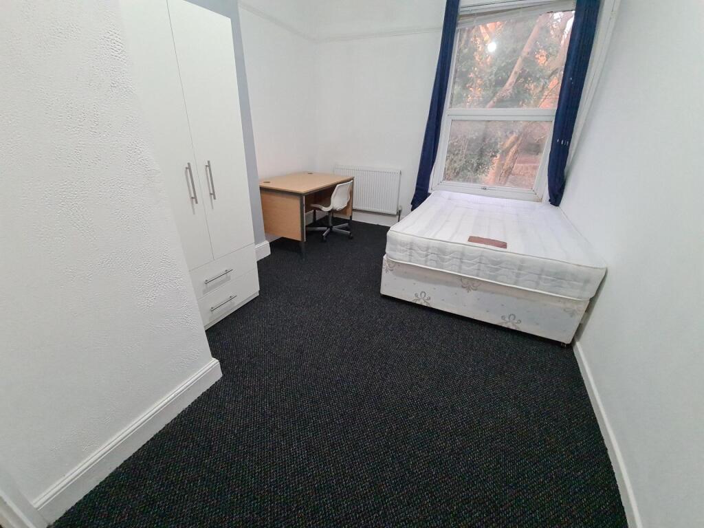 A small, tidy space with a basic toilet setup, ...