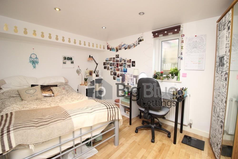 A cozy and well-organized master bedroom featur...