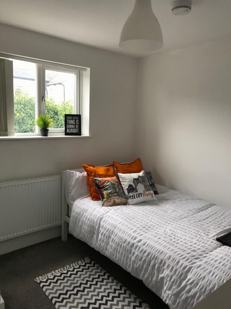 This inviting double bedroom features a cozy at...