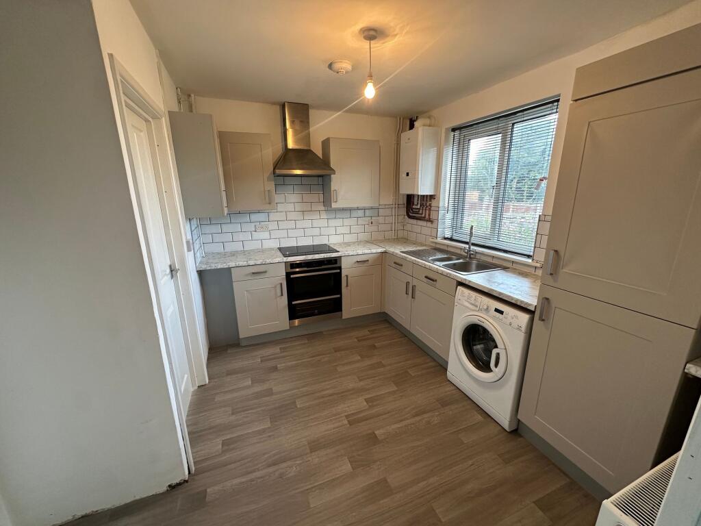 Bright and modern kitchen featuring ample cabin...