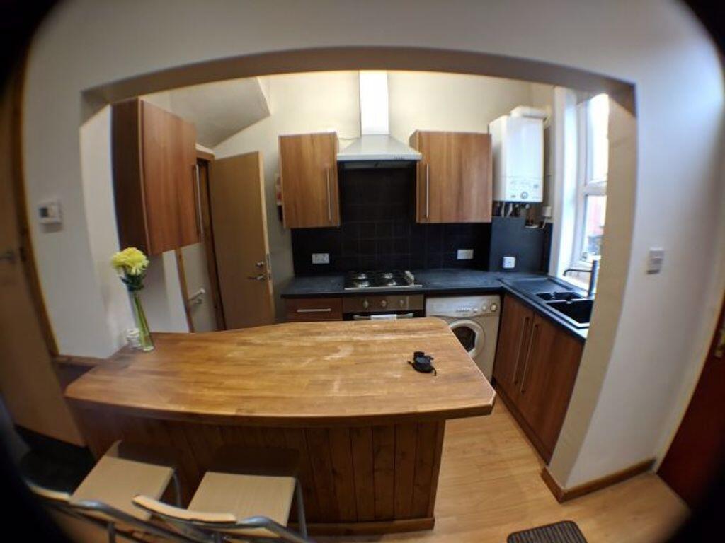 A modern kitchen featuring warm wooden cabinetr...