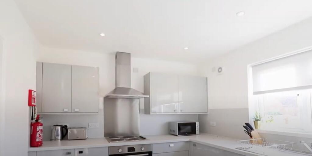 Bright and modern kitchen featuring sleek white...