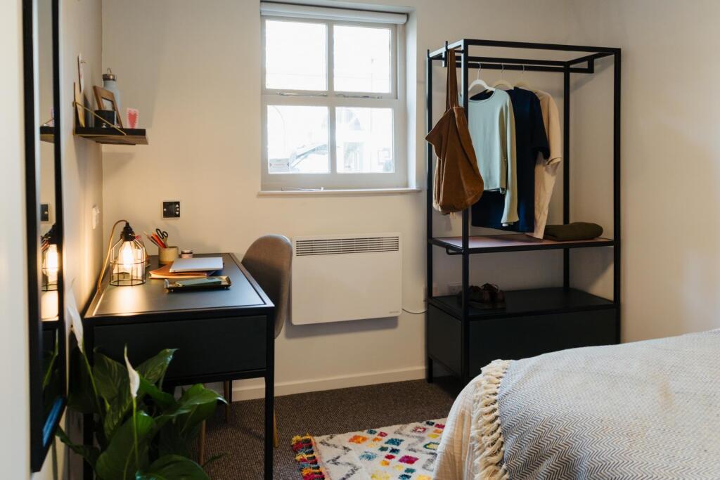 A cozy and well-maintained bedroom featuring a ...