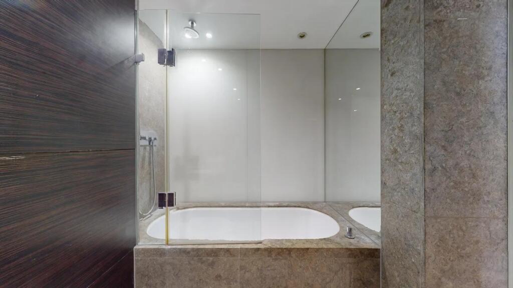 A sleek, modern bathroom suite featuring a buil...