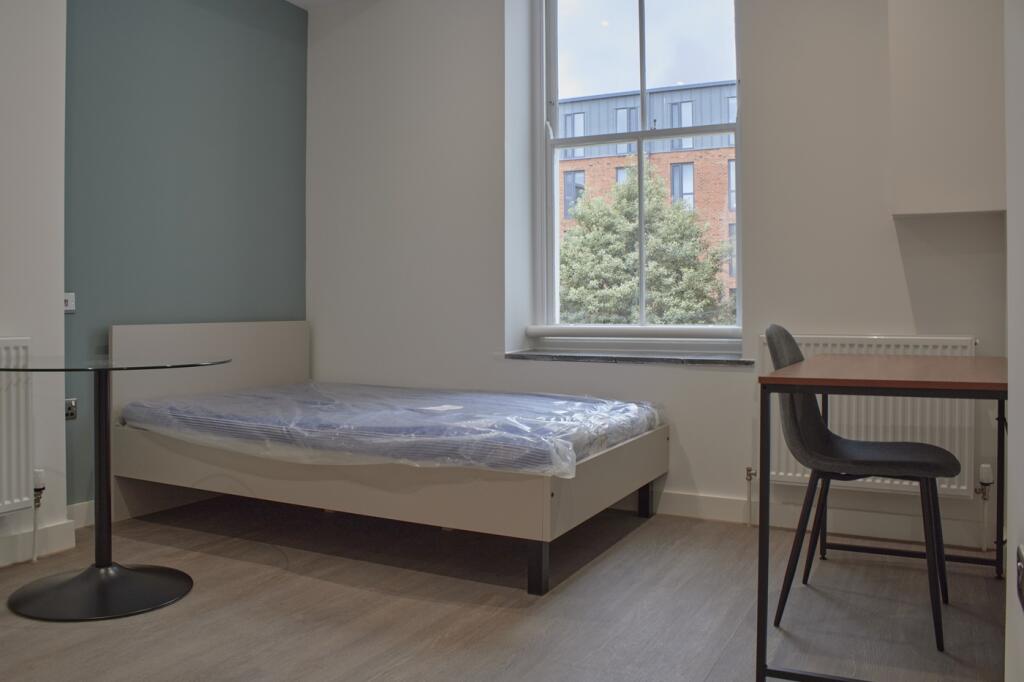 A bright and tidy double bedroom featuring a co...