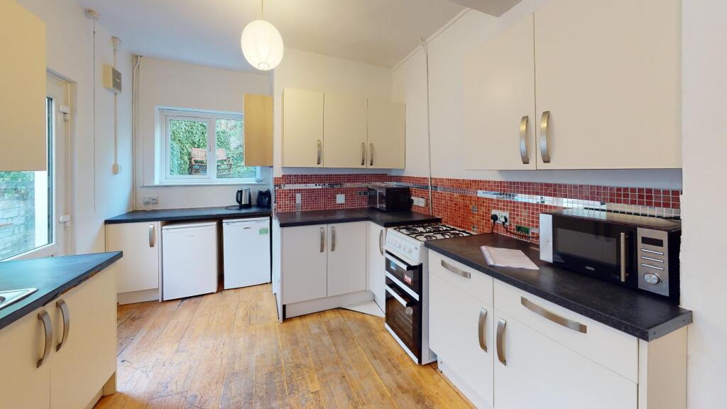 A bright and modern kitchen featuring ample cou...
