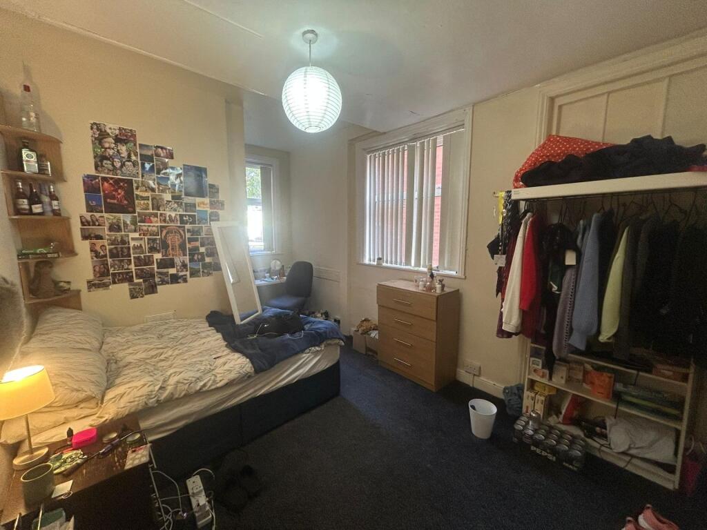 A cozy bedroom with a bed, some personal touche...