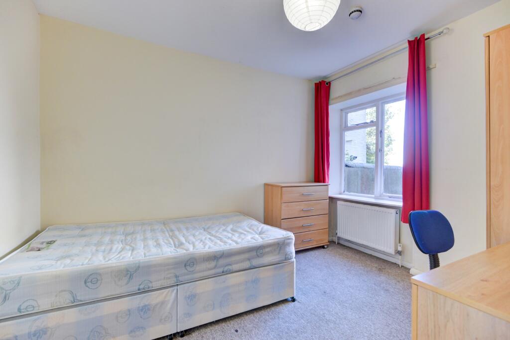 A neat and comfortable single bedroom featuring...