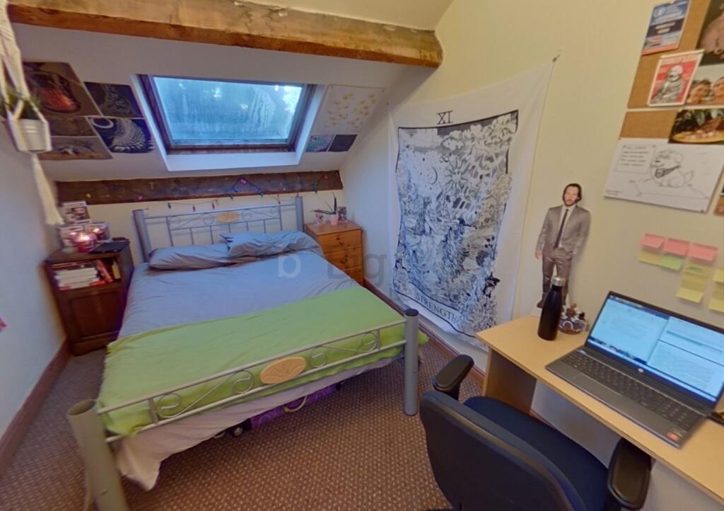 Cozy bedroom with a slanted skylight window all...