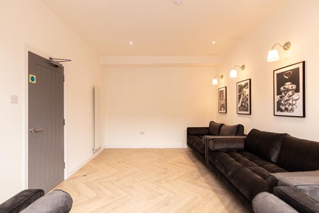 Spacious, modern living room featuring two larg...