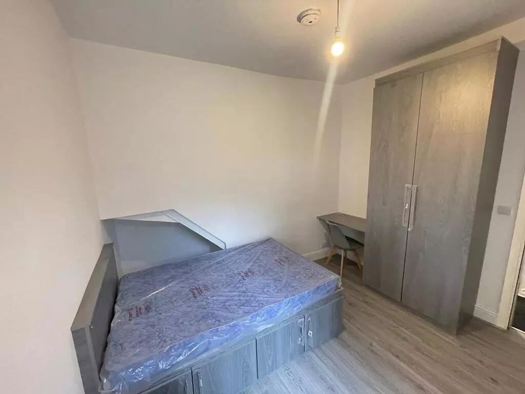 A tidy single bedroom featuring a modern grey s...