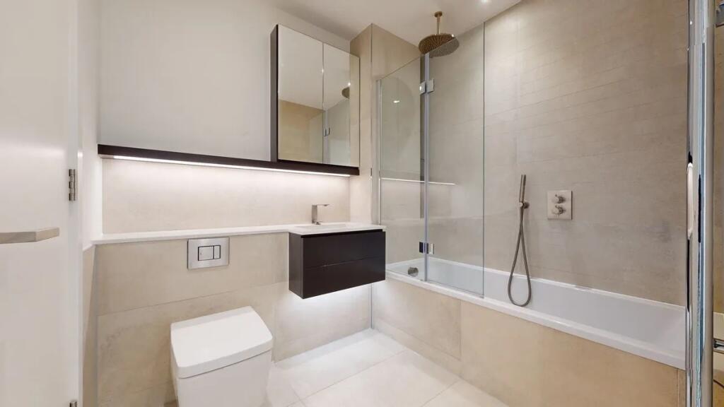 A sleek, modern bathroom suite featuring a spac...