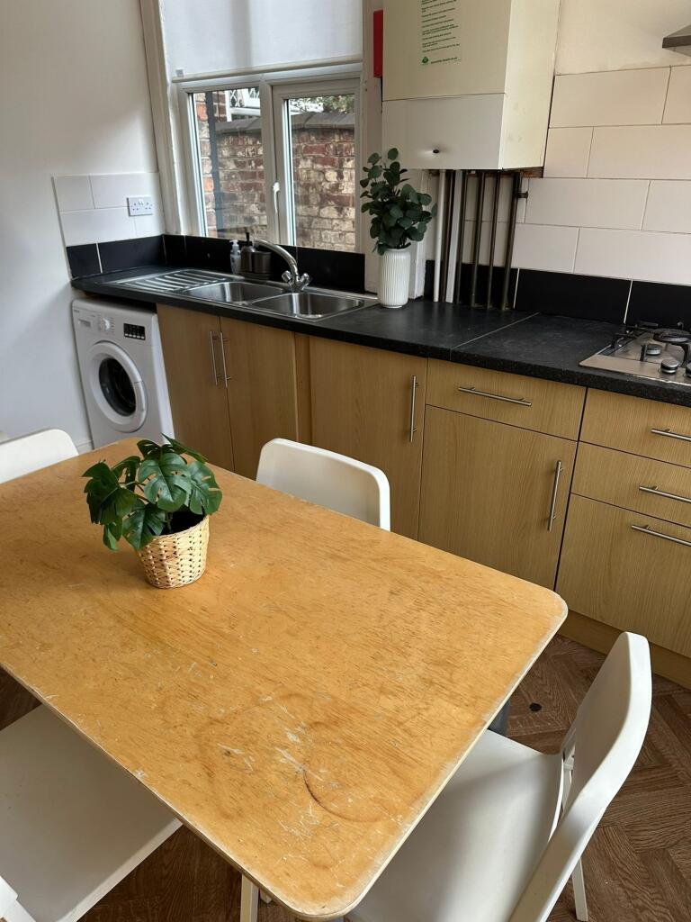 A clean and bright kitchen with a wooden dining...