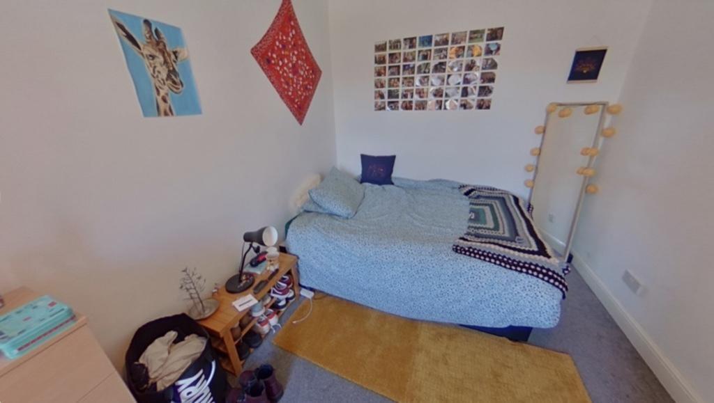 Cozy single bedroom featuring a comfortable bed...