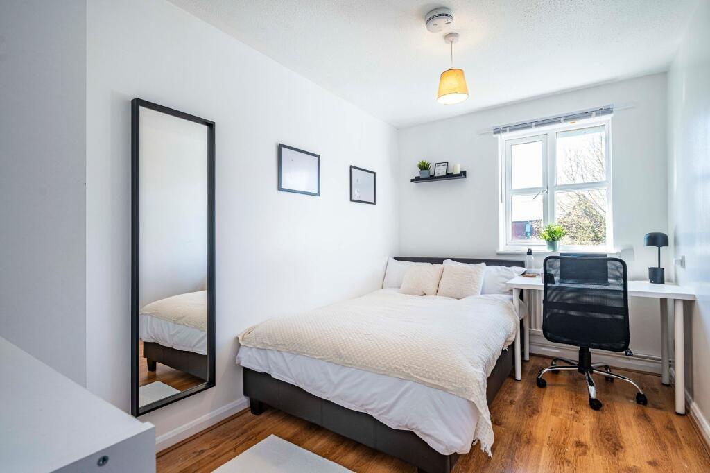 Bright and tidy bedroom featuring a comfortable...