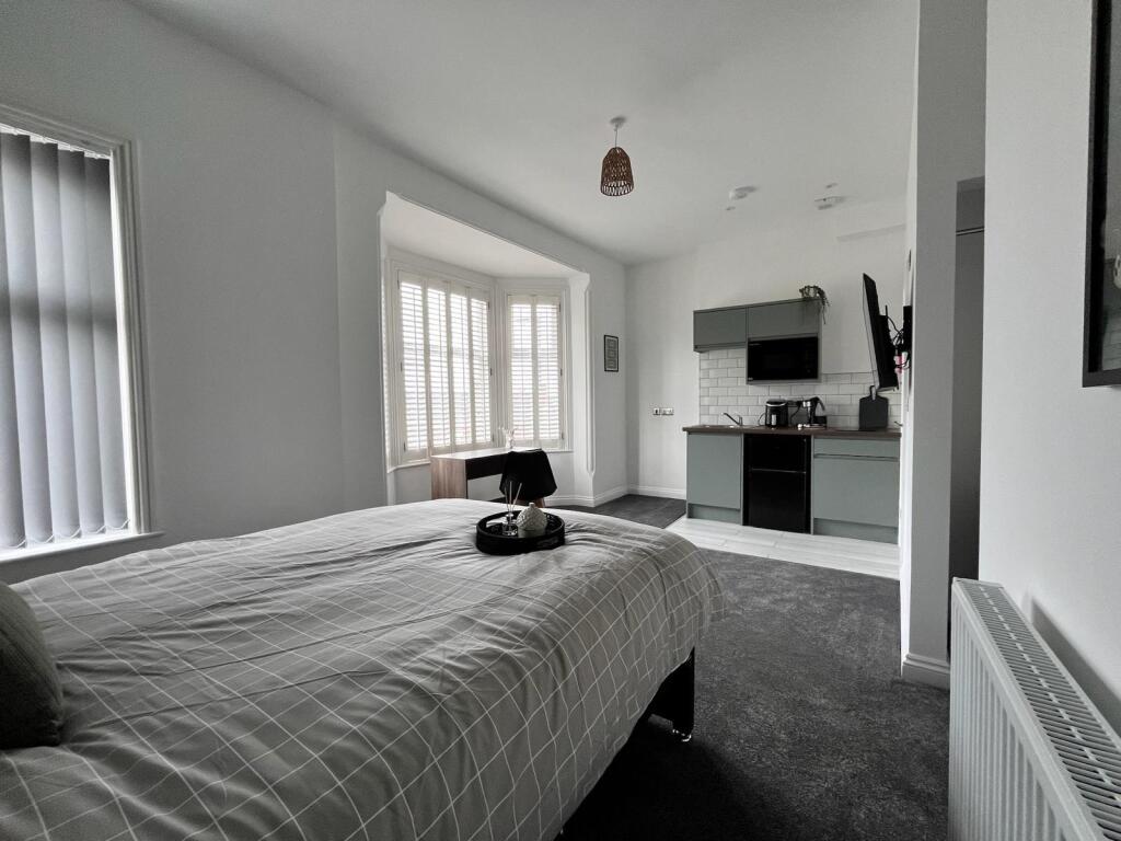 This stylish double bedroom features a comforta...