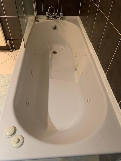 A clean and spacious bathroom featuring a large...