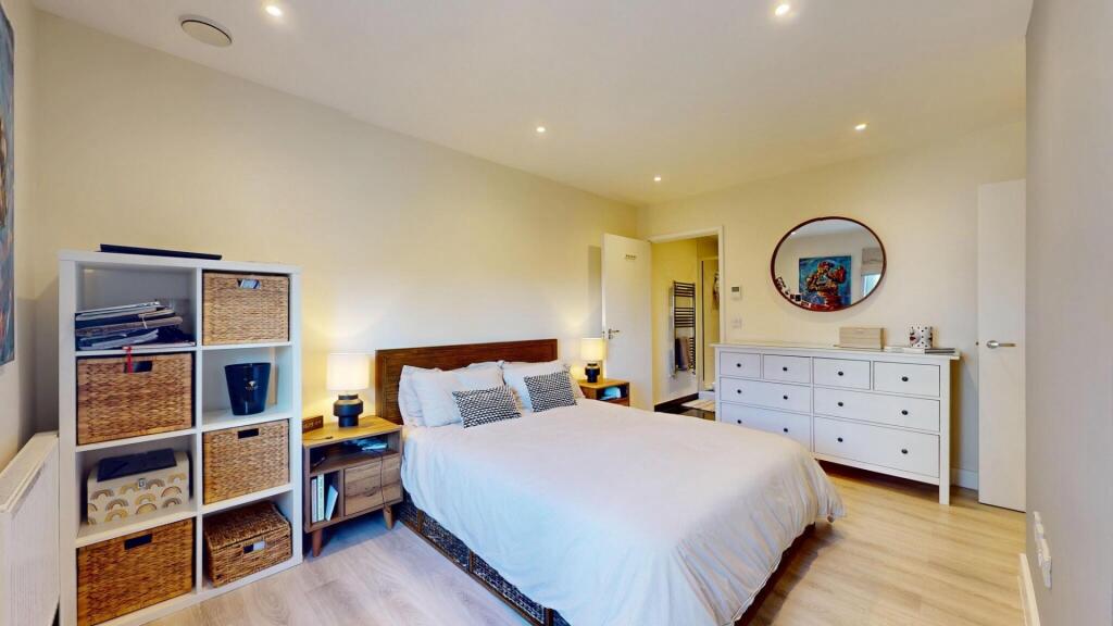 A bright and welcoming bedroom featuring a comf...