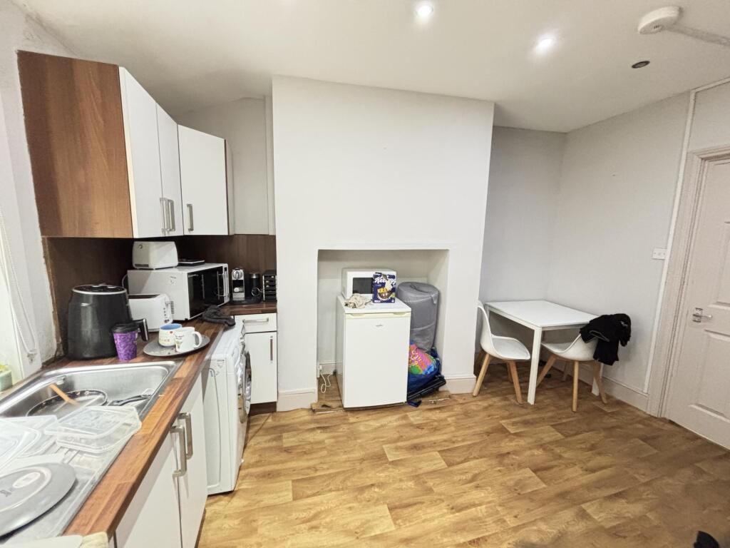A contemporary kitchen area featuring white cab...