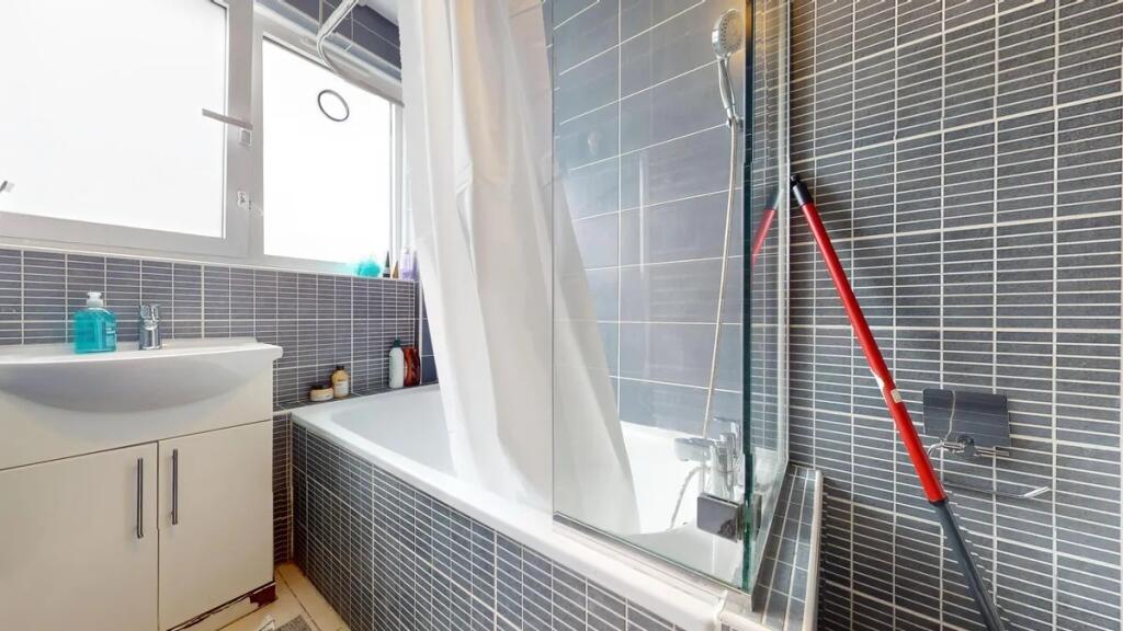 A modern bathroom suite featuring a bathtub wit...