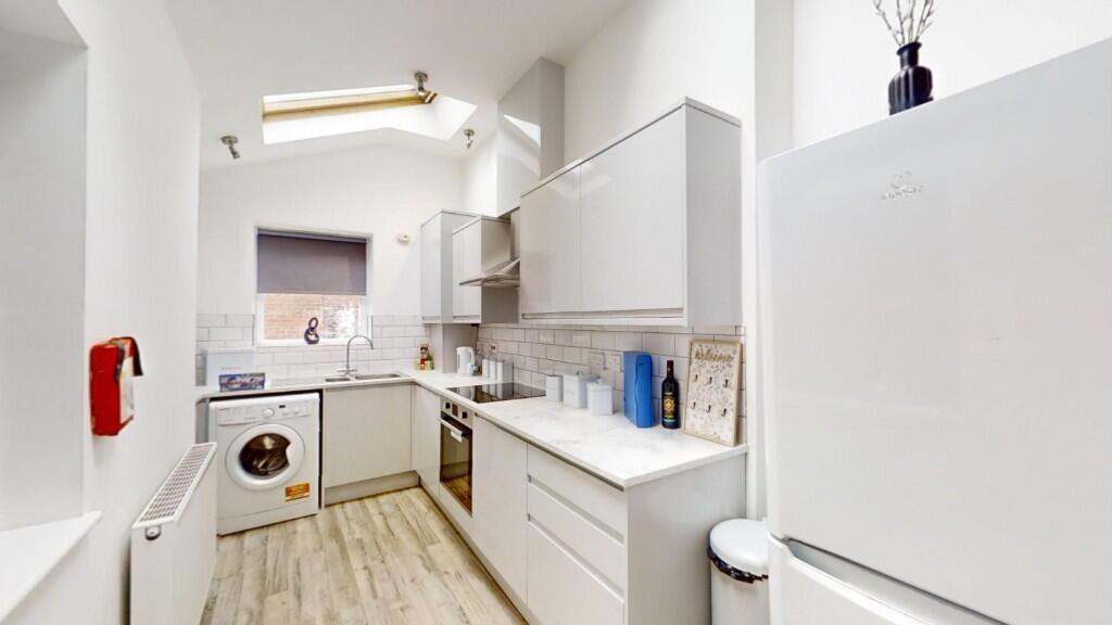 Bright and modern kitchen with white cabinetry ...