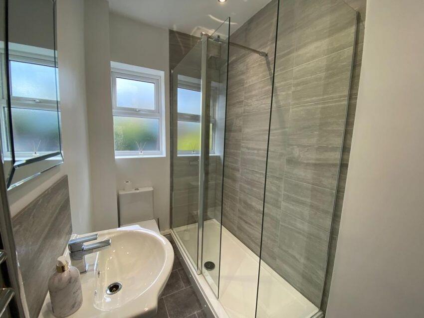 Bright and modern bathroom featuring a large gl...