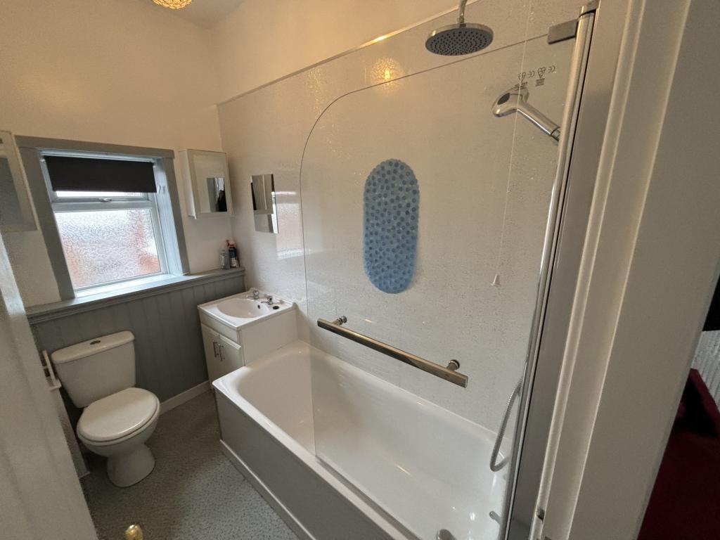 Bright and clean bathroom suite featuring a bat...