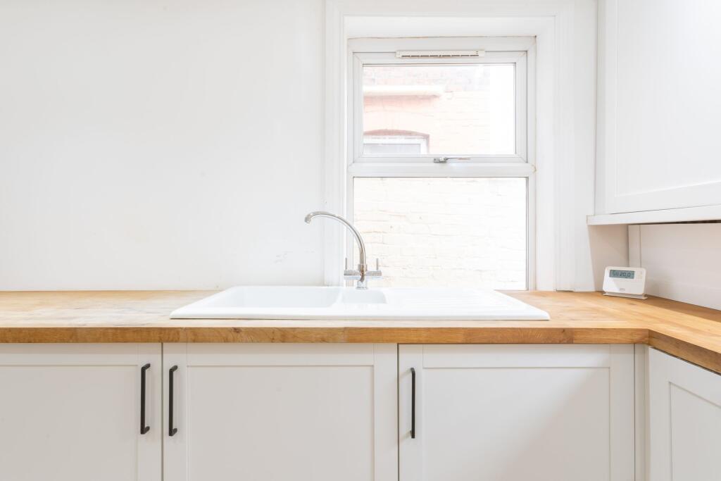 Modern and bright kitchen with a white sink, wo...