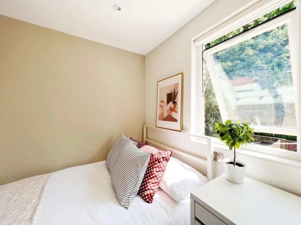 A bright and cozy bedroom featuring a white bed...