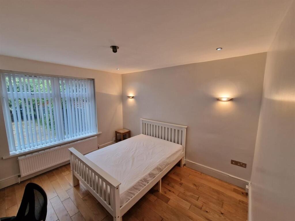 Bright, simply furnished bedroom with a white w...