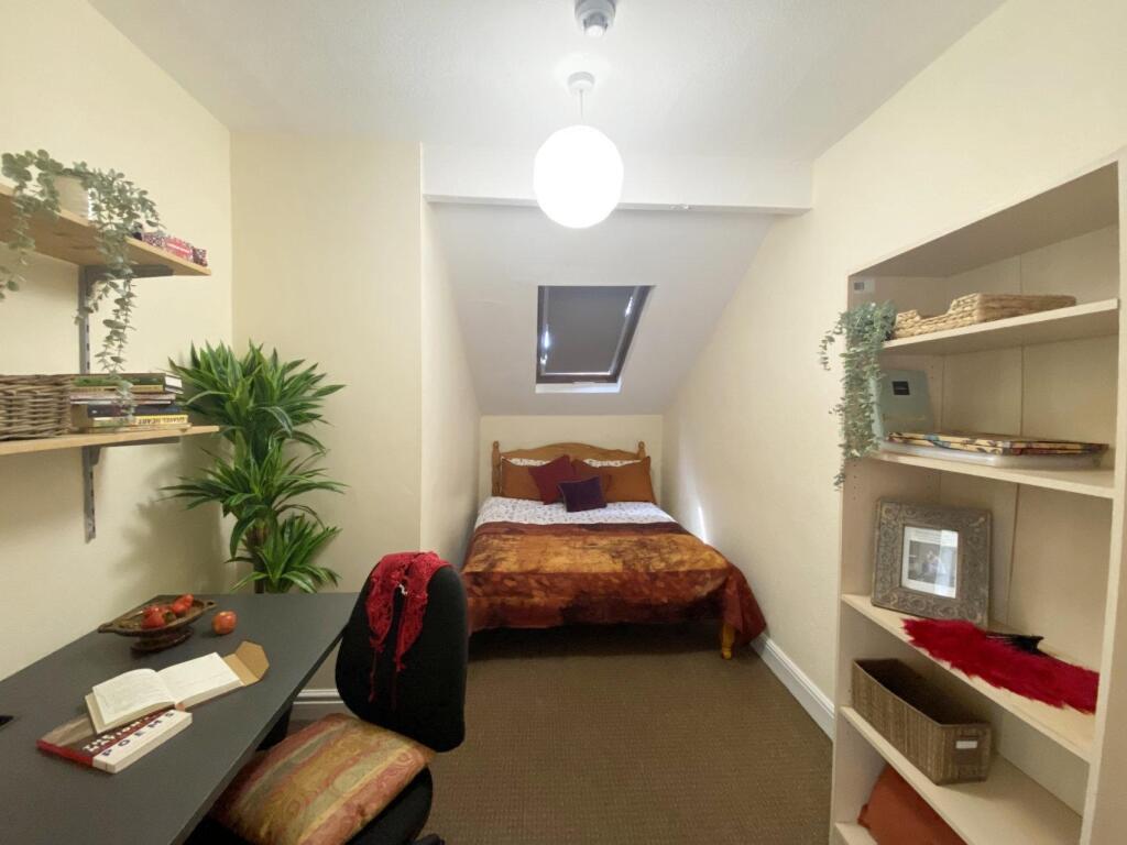 Bright, neatly arranged bedroom with a double b...