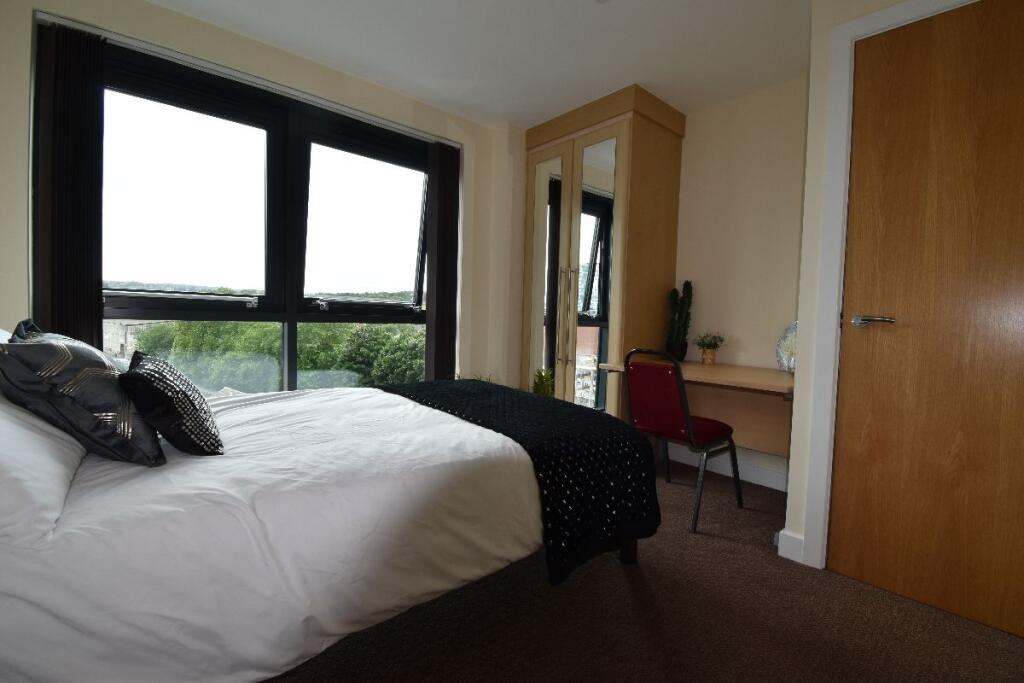 A bright, cozy double bedroom featuring a comfo...