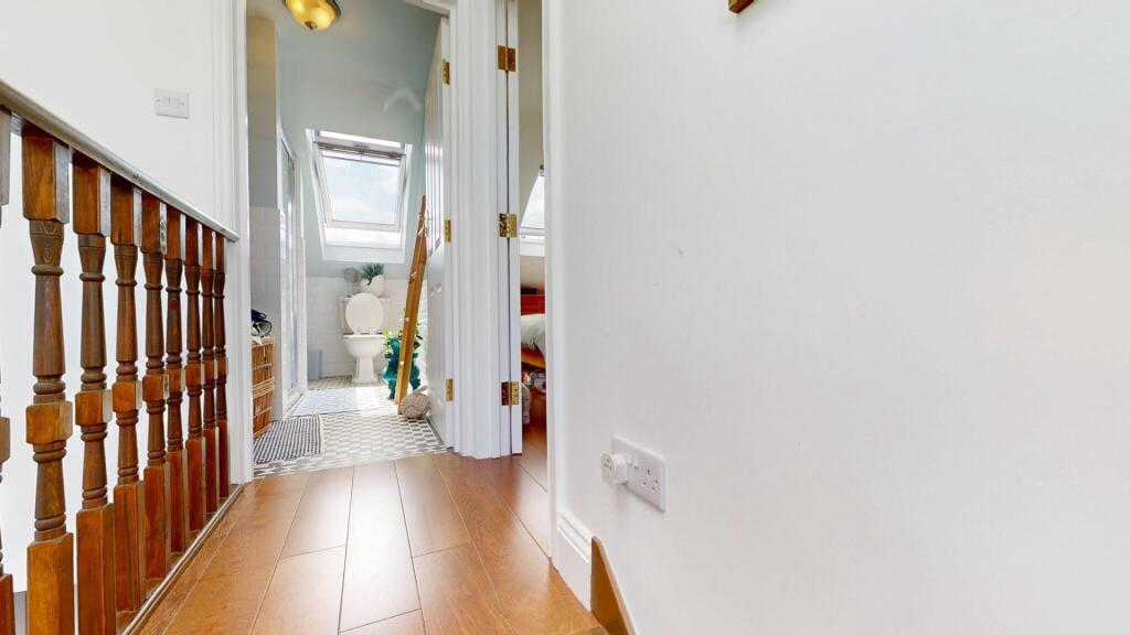A clean and well-lit hallway featuring wooden b...