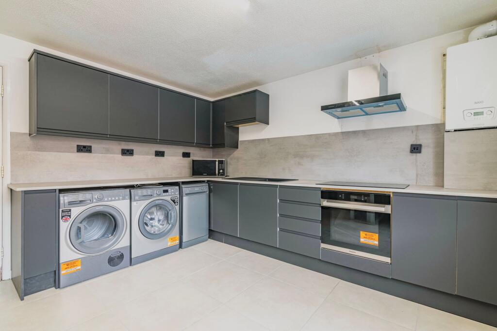 Modern kitchen with sleek grey cabinets, integr...