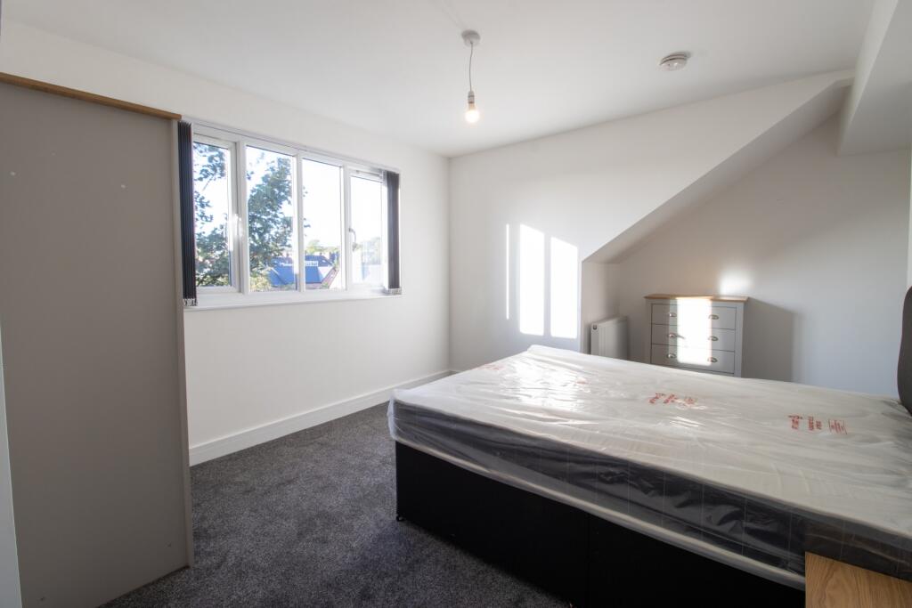 A bright and clean bedroom with a large window ...