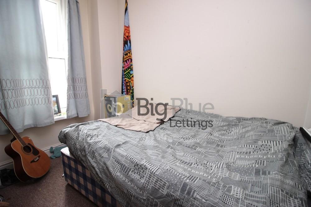 A cozy single bedroom featuring a comfortable b...