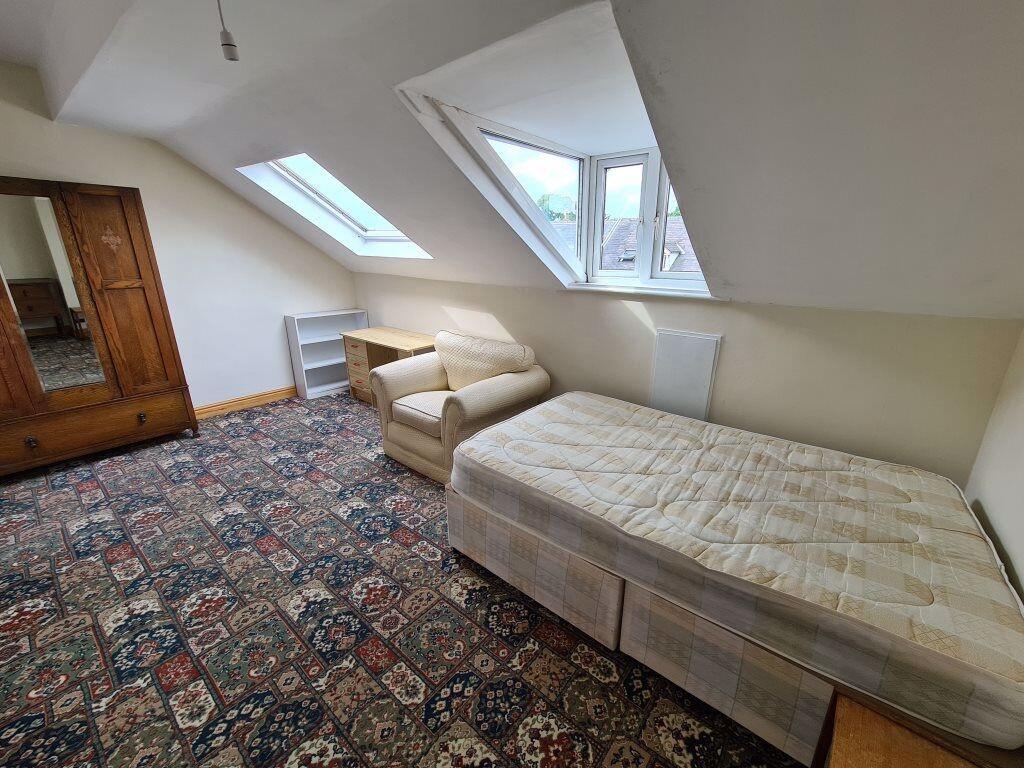 A cozy single bedroom featuring a patterned car...