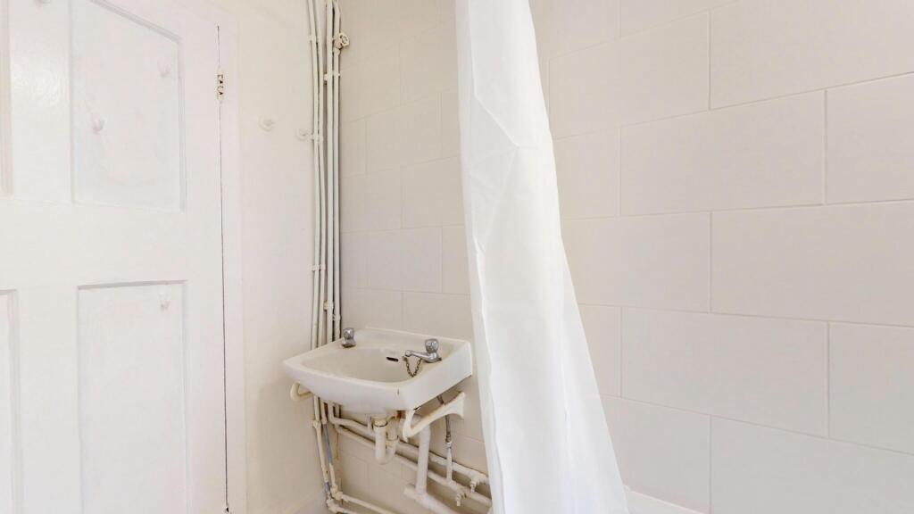 A clean and functional bathroom with a small si...