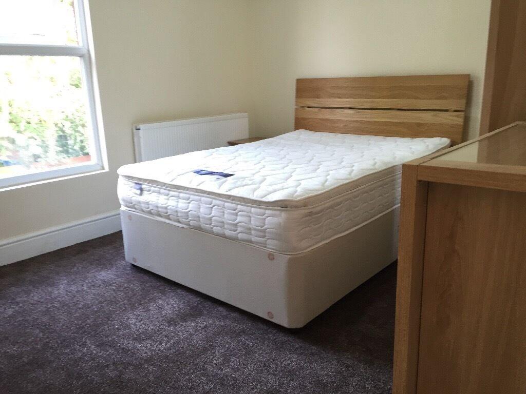 Bright double bedroom featuring a comfortable d...