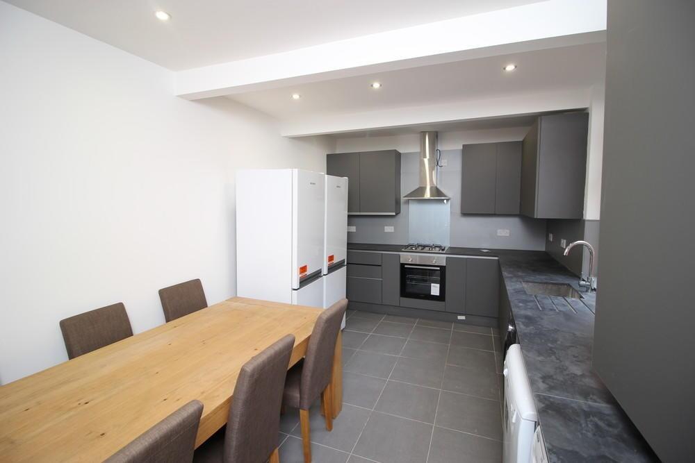 A modern kitchen featuring sleek grey cabinetry...