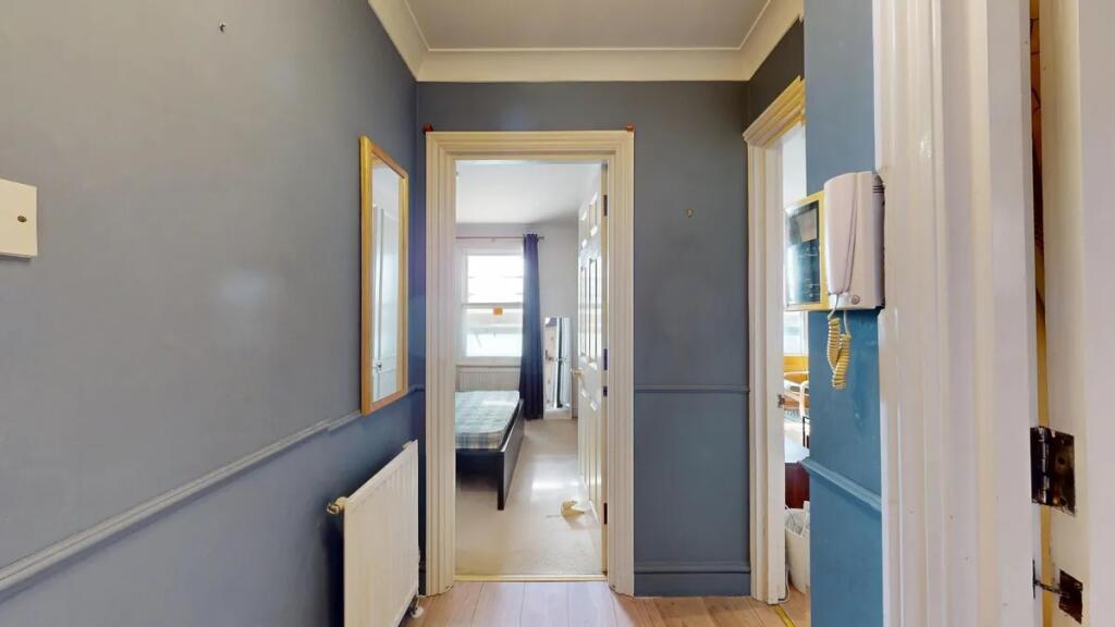 A tidy hallway painted in a modern blue tone wi...