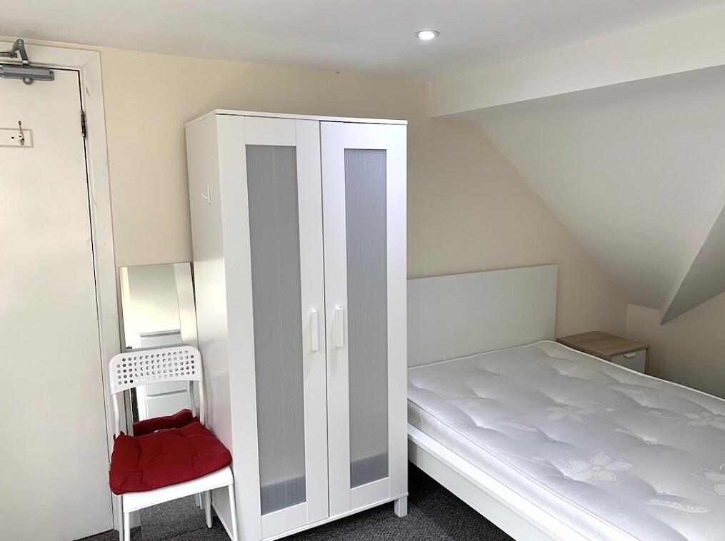 A bright double bedroom featuring a clean white...