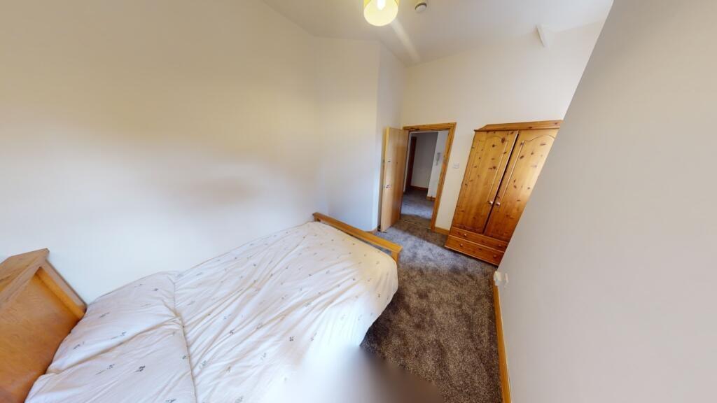 A cozy single bedroom featuring a comfortable b...