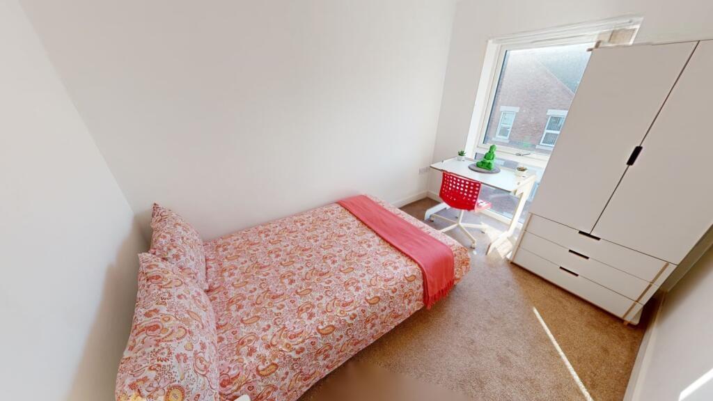 A cozy and tidy single bedroom featuring a bed ...
