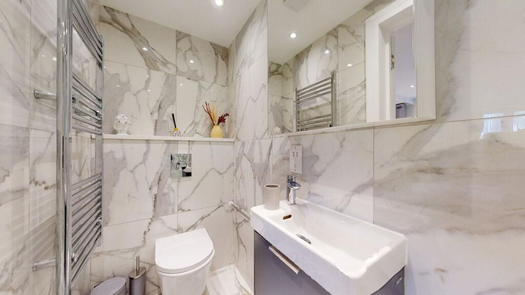 A sleek and modern single toilet room featuring...