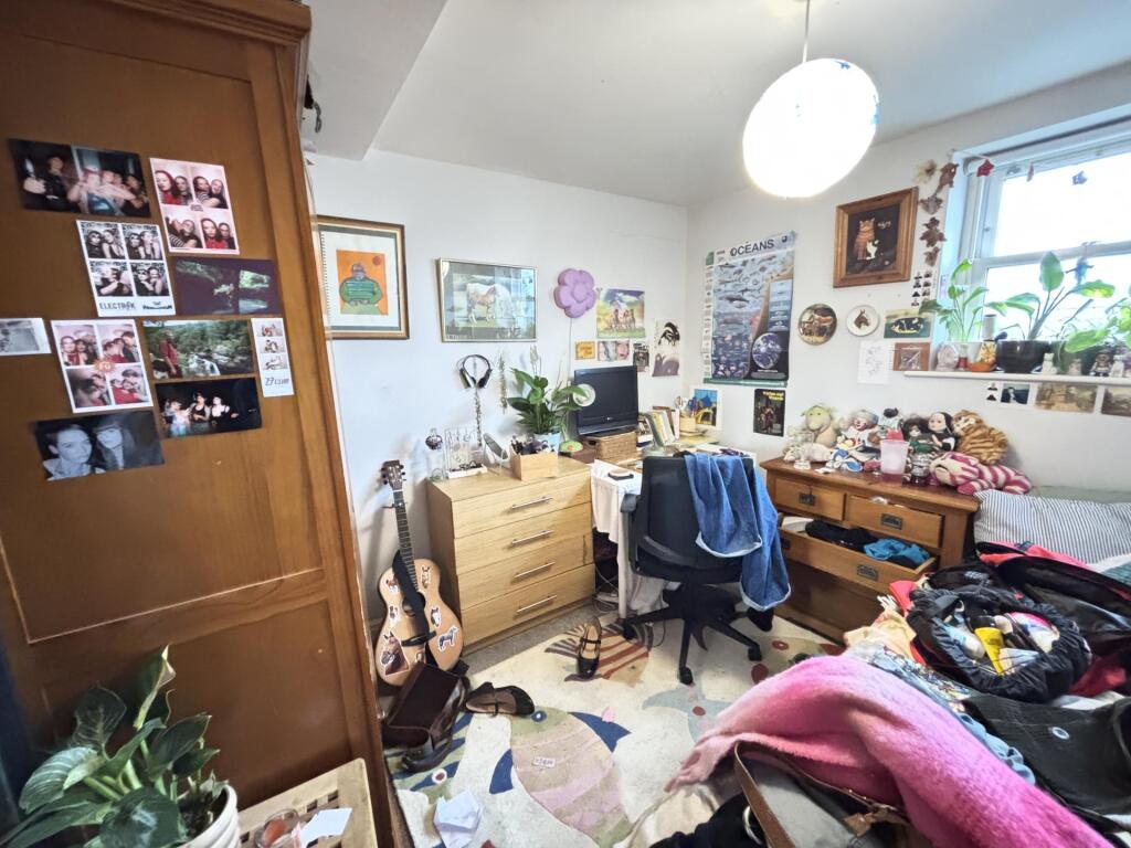 A cozy bedroom featuring a bed, study desk, and...