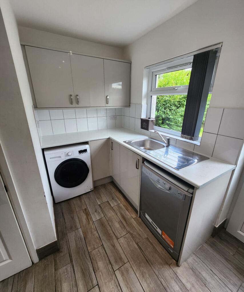 A bright and modern kitchen featuring white cab...